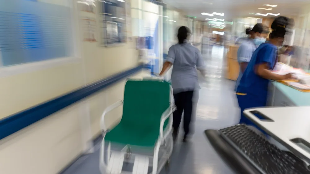 A blurred picture of a nurse pulling a wheelchair on a hospital ward