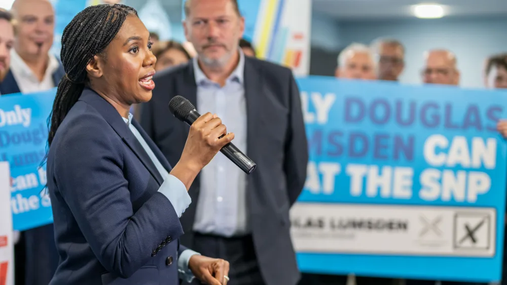 Kemi Badenoch speaking into a mic as Douglas Lumsden looks on