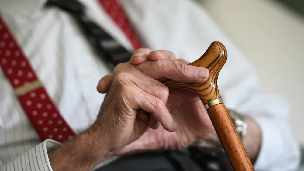 An old man's hands on a walking stick