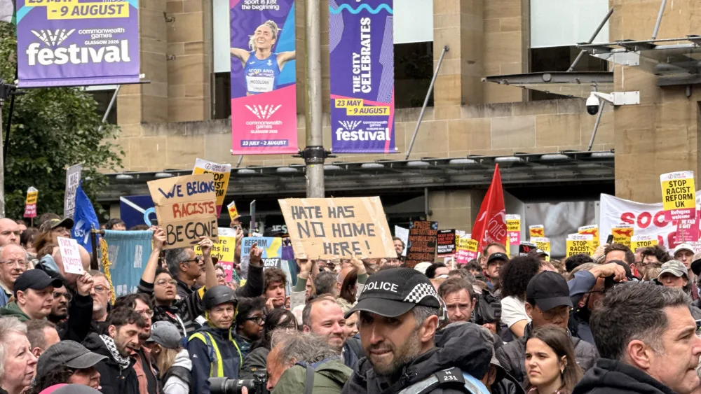Anti-racism rally, with people holding up placards reading 'Hate has no home here'
