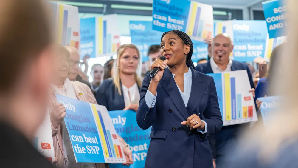 Kemi Badenoch speaking to a crowd using a microphone