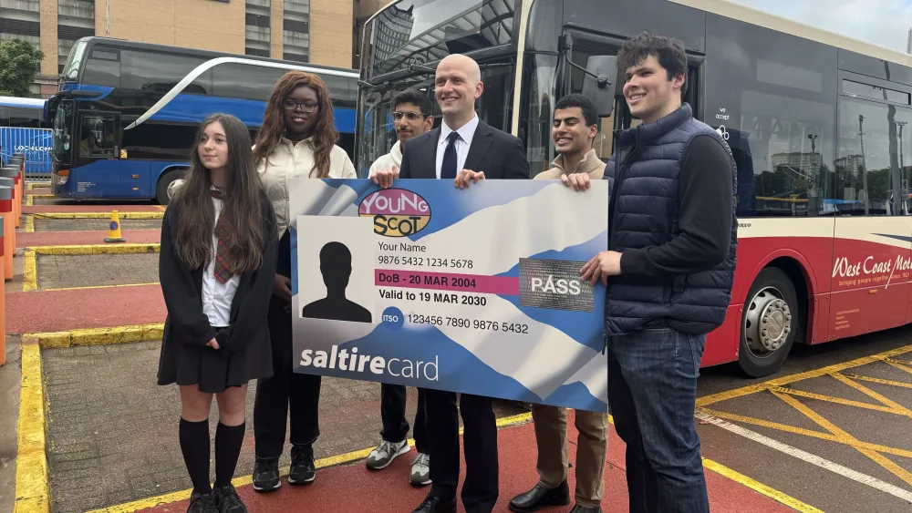 Stephen Flynn and a group of young people holding a big NEC card