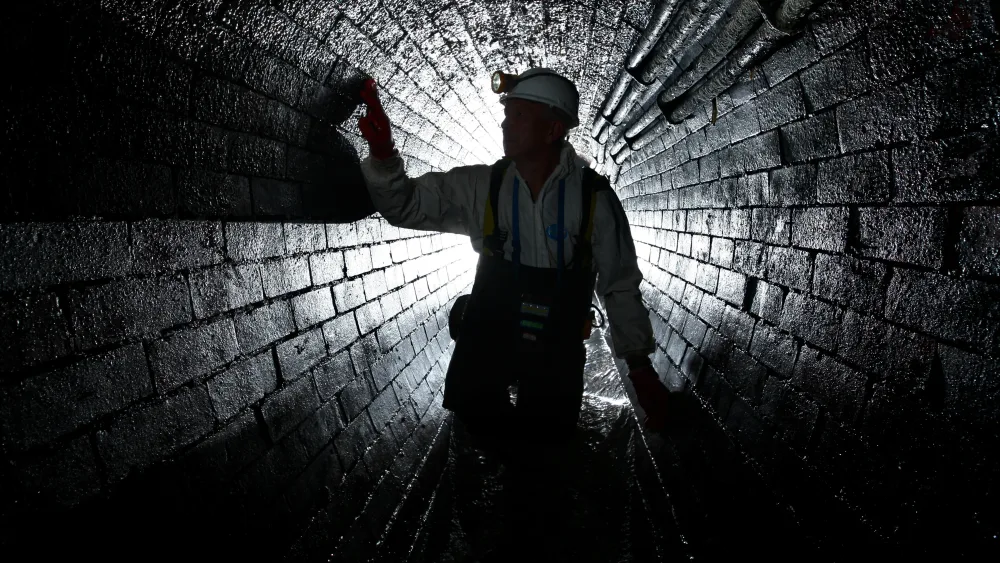 A man inspecting the inside of a sewer