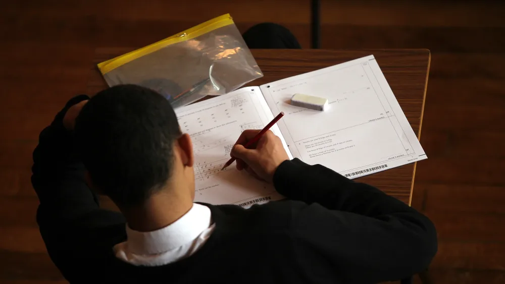 A pupil writing in a school book