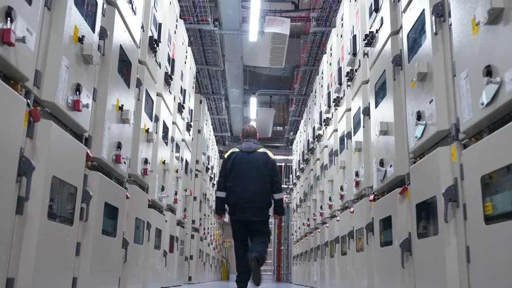 A man walks down a data centre corridor