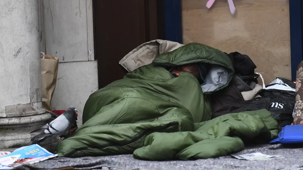 A homeless man sleeping in the doorway of a store