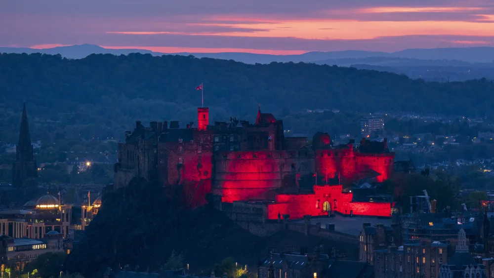 Edinburgh Castle is shown bathed in a red light