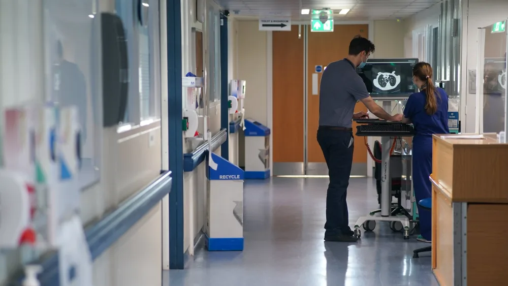 View of an NHS ward, with hospital staff in the background