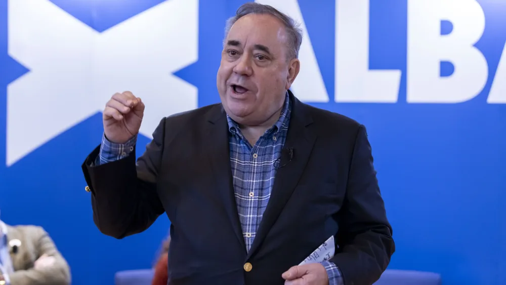 Alex Salmond speaking in front of Alba Party signage