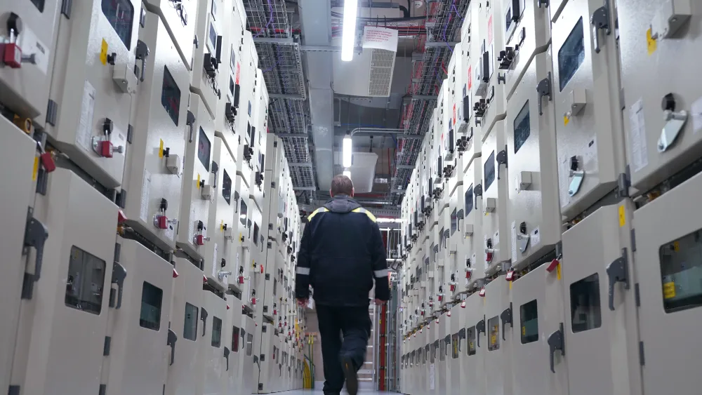 A man walks down a data centre corridor