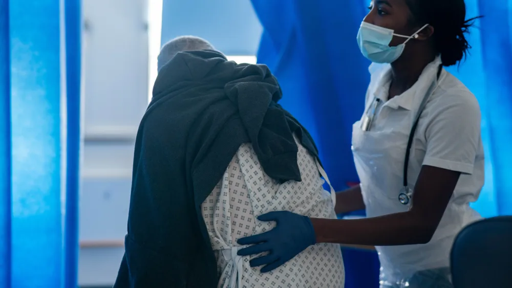 A hospital worker helping a patient