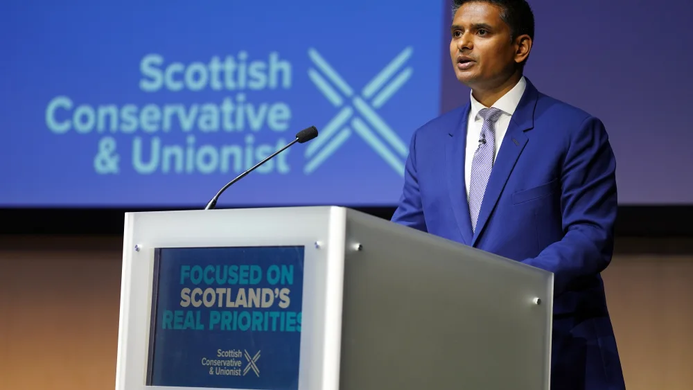 Dr Sandesh Gulhane speaking from a lectern featuring Scottish Conservative signage