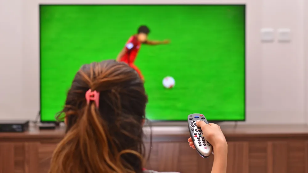 Woman watching a football match on TV