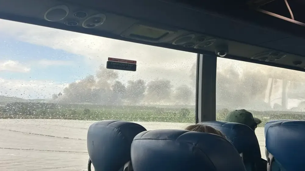 Burning waste dump viewed from inside a bus
