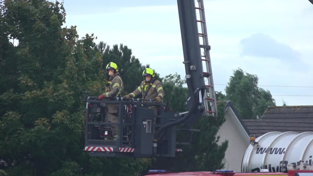 Firefighters board a height appliance to help stop the fire. (Ryan McDougall/PA)