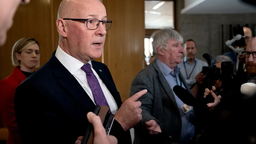 First Minister John Swinney speaking to journalists