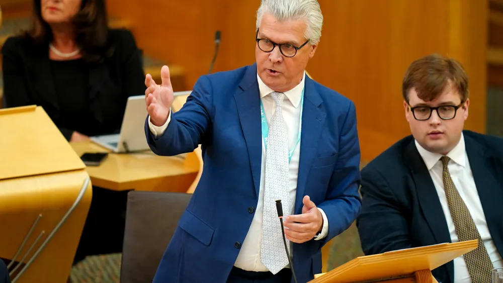 Malcolm Offord standing while speaking in Holyrood
