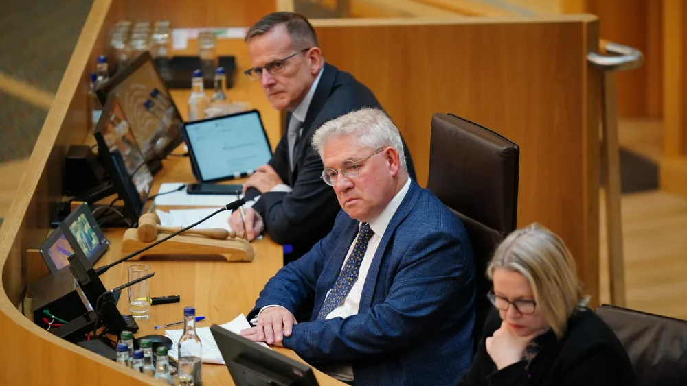 Kenneth Gibson seated in the Presiding Officer's chair at Holyrood