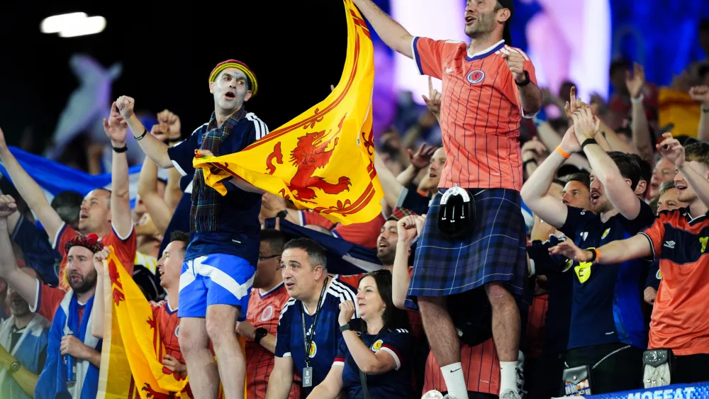 Scotland fans celebrating and holding Scottish flags