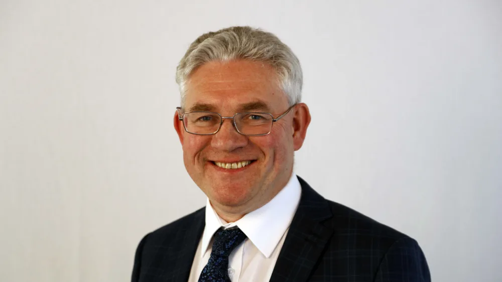 Handout head and shoulders photo of Kenneth Gibson smiling