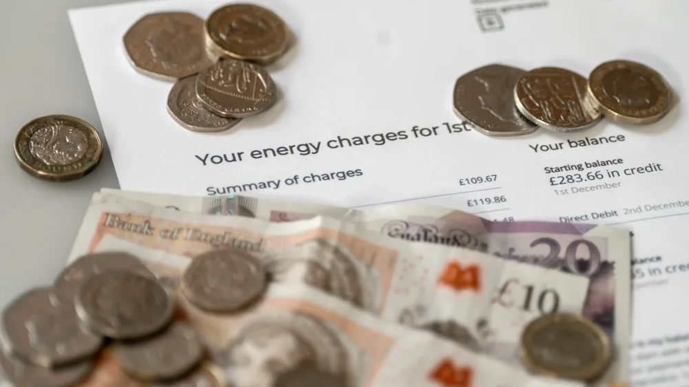 Money is stacked on top of an energy bill