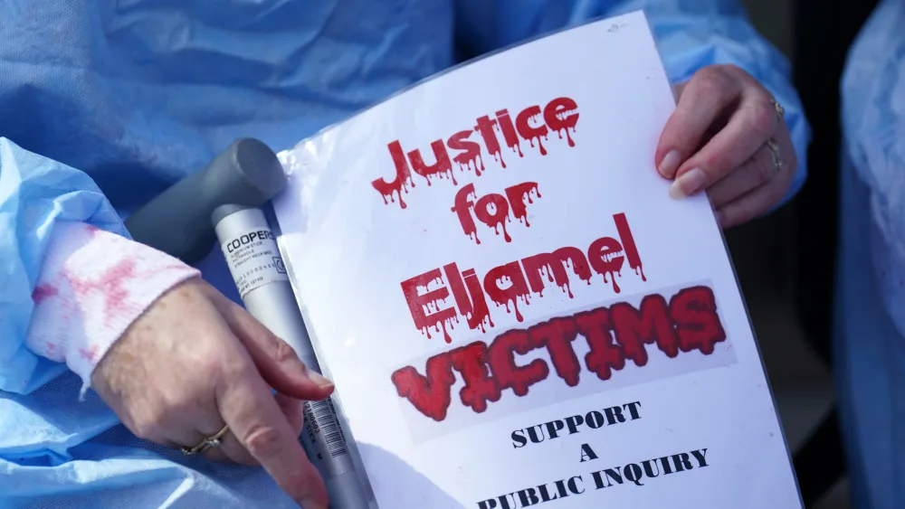 Person holding Justice for Eljamel Victims poster