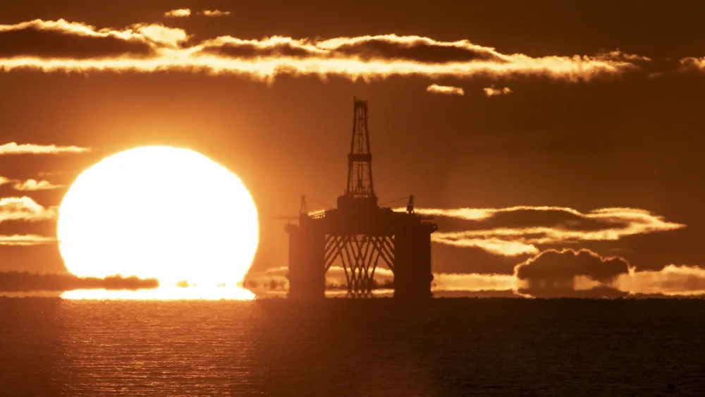 Oil platform with the sun rising behind it