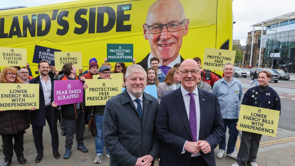 John Swinney and Angus Robertson smiling in front of SNP campaigners