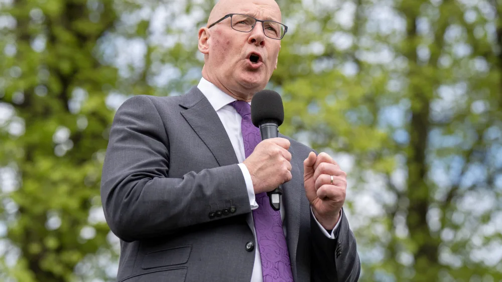 John Swinney speaking into a microphone