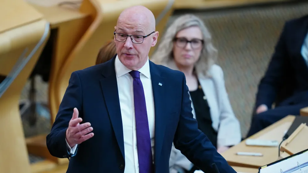 John Swinney gesturing with his hands during a speech