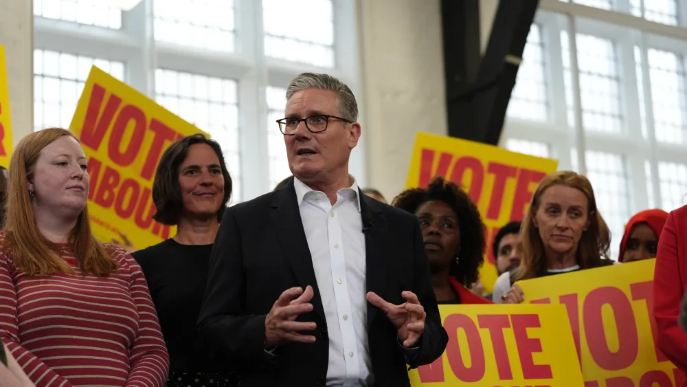 Keir Starmer speaking in front of campaigners hold placards saying 'Vote Labour'