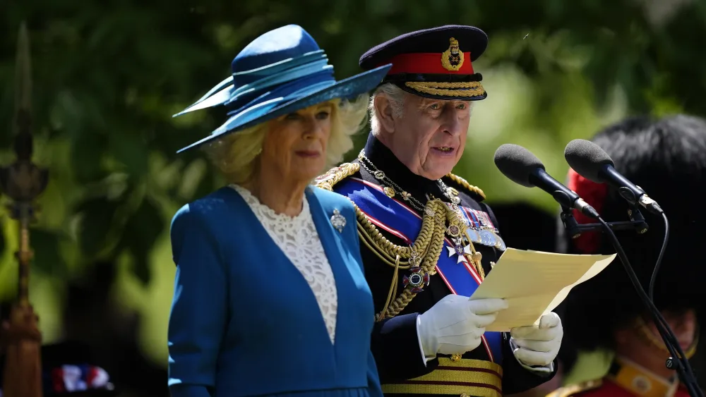 The King speaking, while in military uniform, with the Queen alongside him
