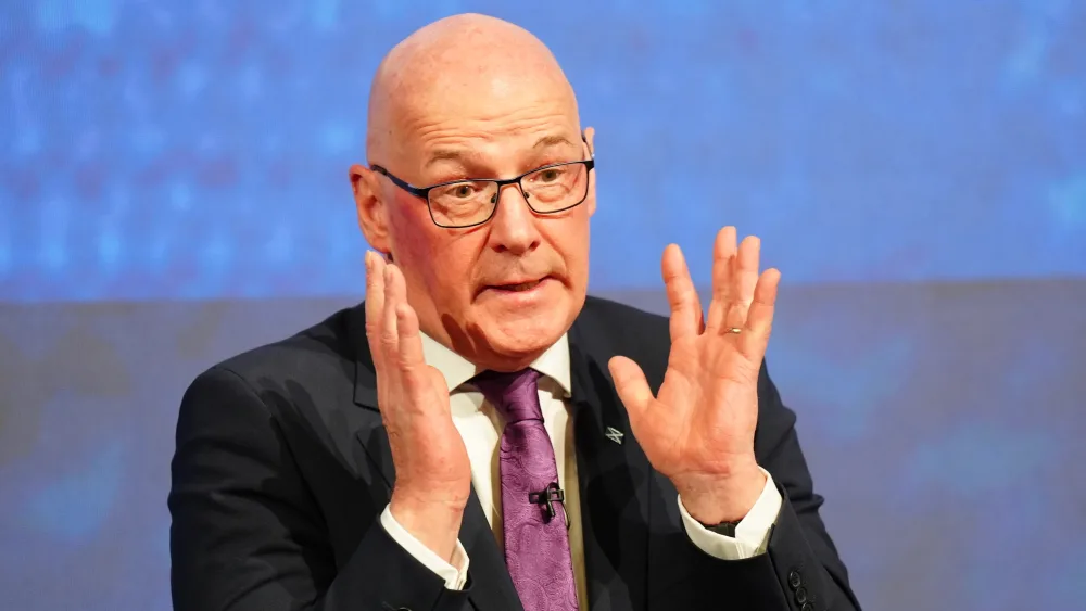 John Swinney gesturing with his hands in front of him