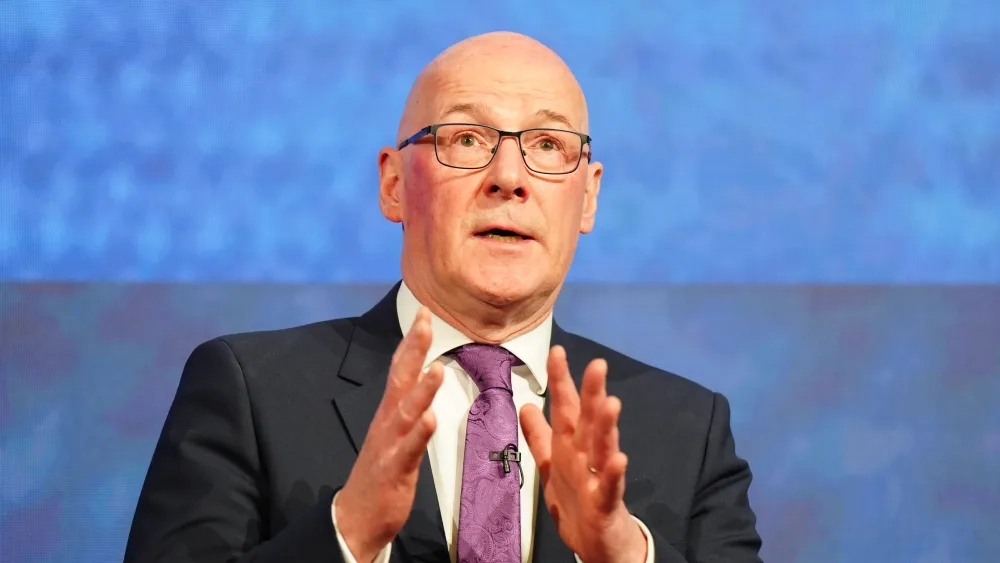 John Swinney gesturing with his hands while speaking