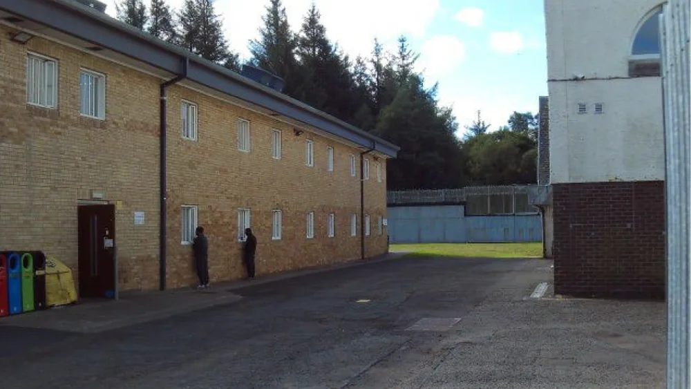 Male detainees looking through windows of the female unit at Dungavel immigration removal centre