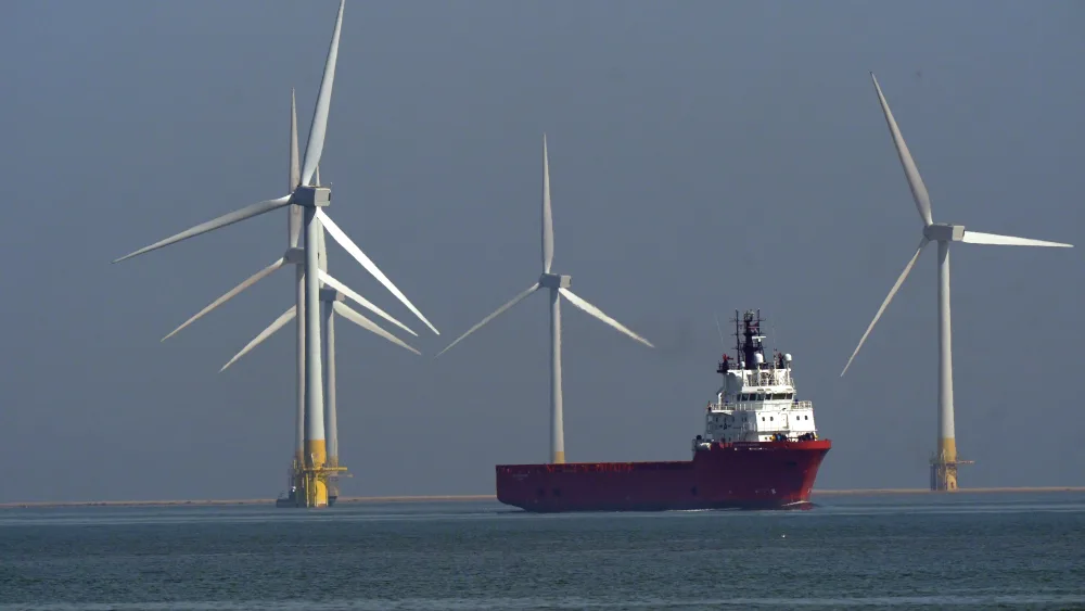 Wind turbines at sea, with a ship amongst them