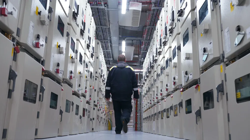 A man walks down a data centre corridor