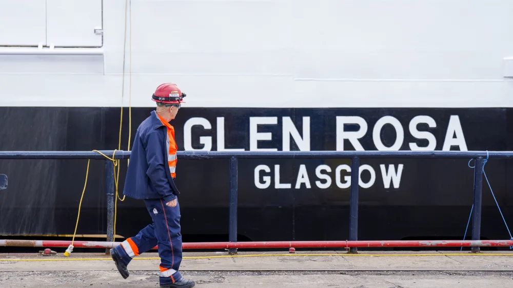 A shipyard working in boilersuit and hard had walks past the Glen Rosa ferry