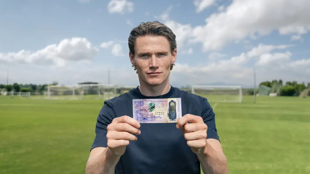 Scott McTominay holding up a banknote