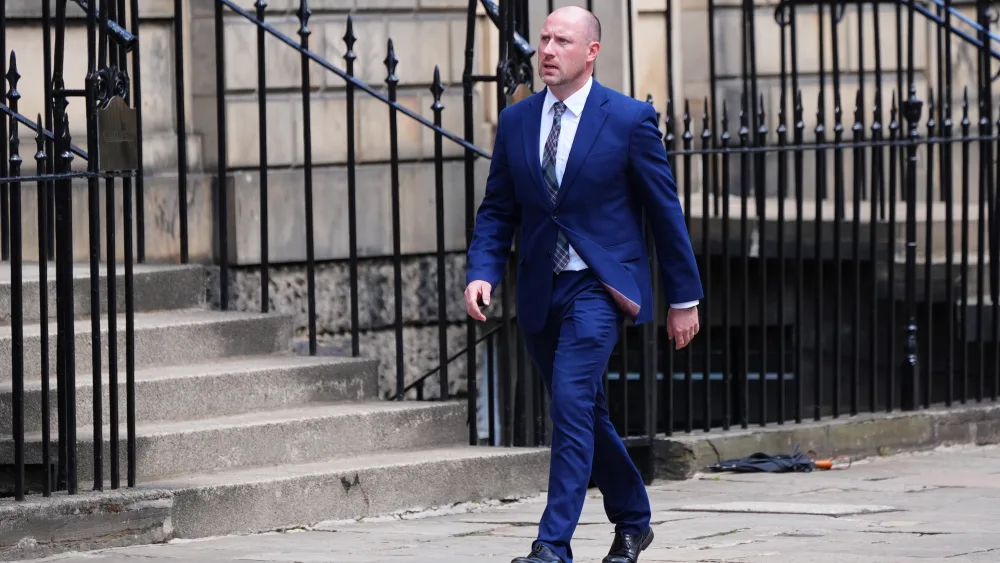 Justice Secretary Neil Gray walks down a street