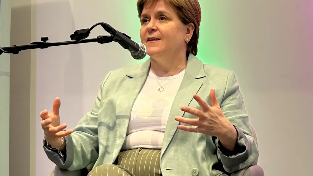 Nicola Sturgeon gesturing with speaking, seated in an armchair