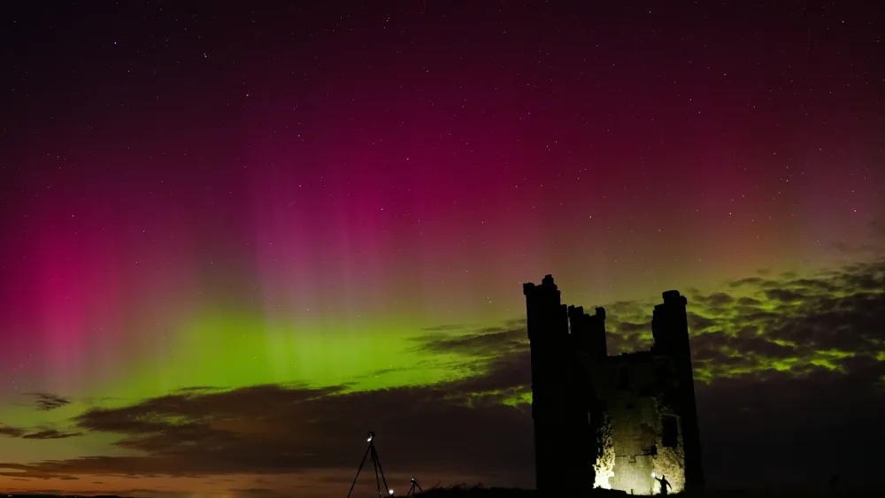 The aurora borealis lighting up skies over the ruins of Dunstanburgh Castle