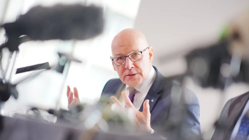 John Swinney gesturing with his hands while speaking