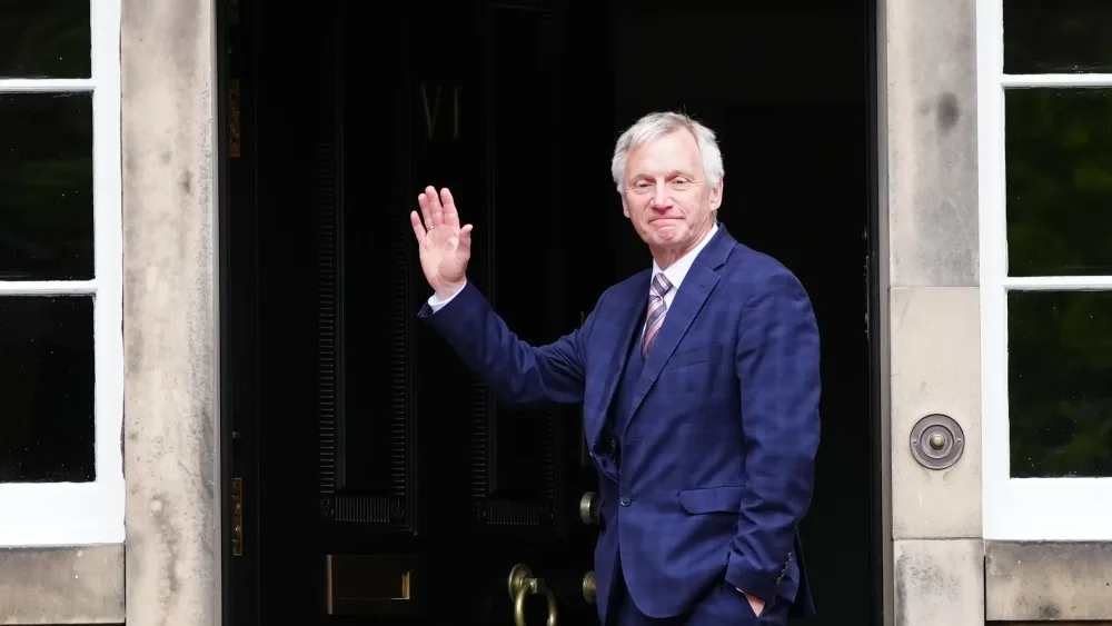Ivan McKee waving on a doorstep