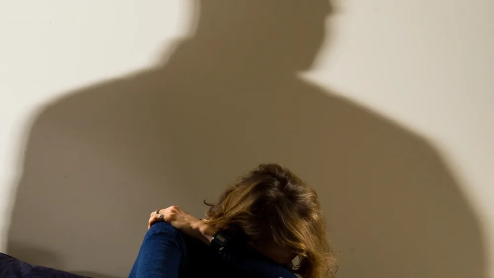 A picture posed by a model showing a woman cowering in fear