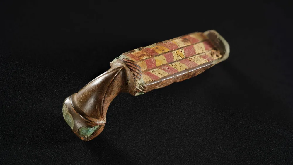 A Roman brooch sits on a black background