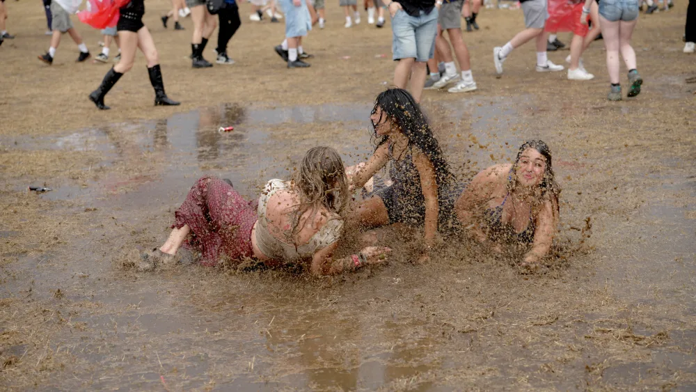 Festivalgoers frolicking in the rain during the Reading Festival at Little John’s Farm, Reading, Berkshire