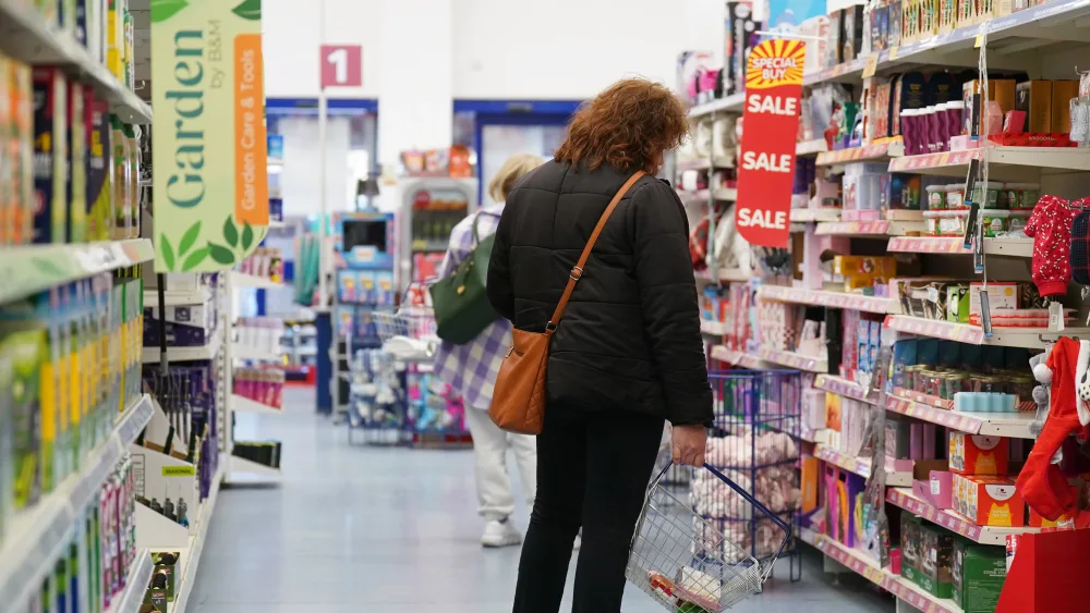 A shopper in an aisle holding a basket