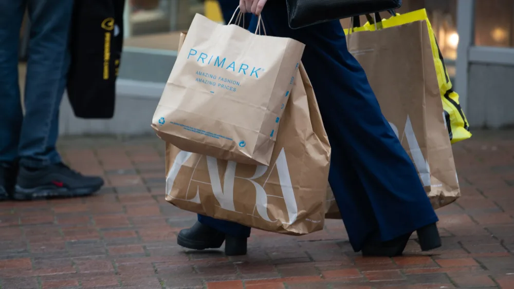 A woman carrying shopping bags while walking on a street