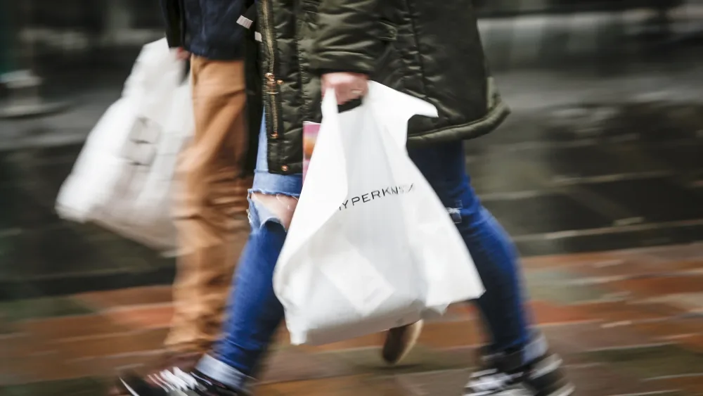 A shopper carrying bags in a high street
